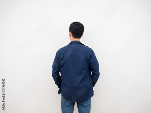 Handsome man back view in jean suit standing at studio white background
