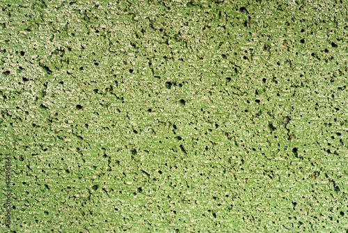 Concrete wall painted in green color. Close up view