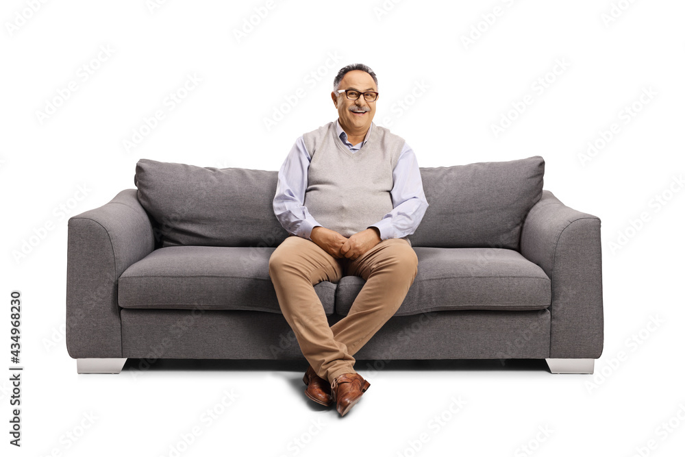 Mature man sitting on a sofa and smiling at camera Mature man sitting on a sofa and smiling at camera