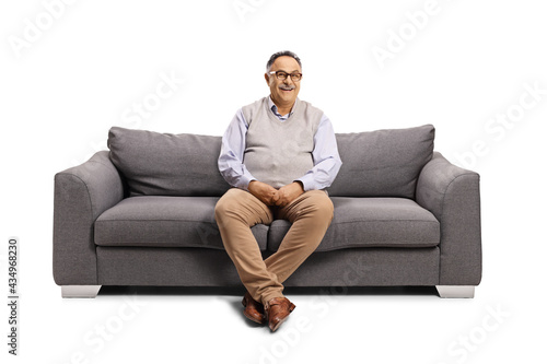 Mature man sitting on a sofa and smiling at camera