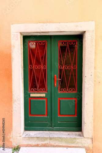 Czerwono zielone drzwi wejściowe do starego budynku na starym mieście. 