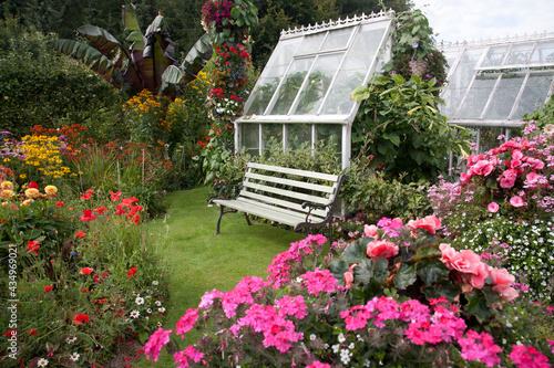 Seat outside a Victorian Greenhouse overlooking a beautiful cottage flower garden