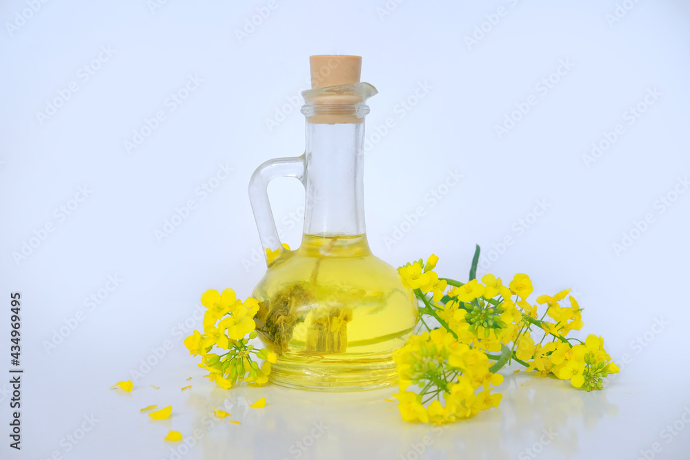 close-up of appetizing yellow oil in a bottle, glass jug, bright rapeseed flowers, vegetable oil cooking concept, cooking healthy food at home, selling nature products close-up of appetizing yellow oil in a bottle, glass jug, bright rapeseed flowers, vegetable oil cooking concept, cooking healthy food at home, selling nature products