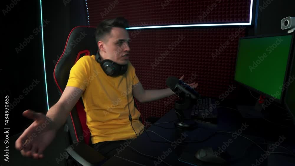 A man with headphones communicates online via the Internet and emotionally swears at his interlocutor. Anger and negative emotions. A man with headphones communicates online via the Internet and emotionally swears at his interlocutor. Anger and negative emotions.