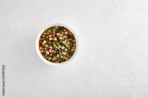 plate of cold okroshka soup with kvass on a light background with space for text