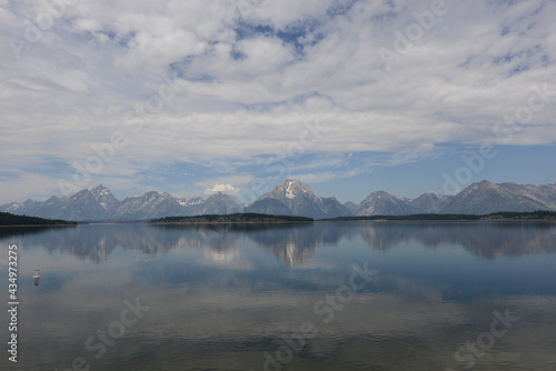 Scenic view of a lake with mountains in the background and lake reflections in Grand Teton National Park on a cloudy day