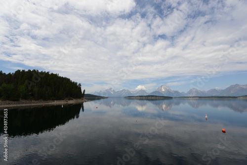 Scenic view of a lake with mountains in the background and lake reflections in Grand Teton National Park on a cloudy day