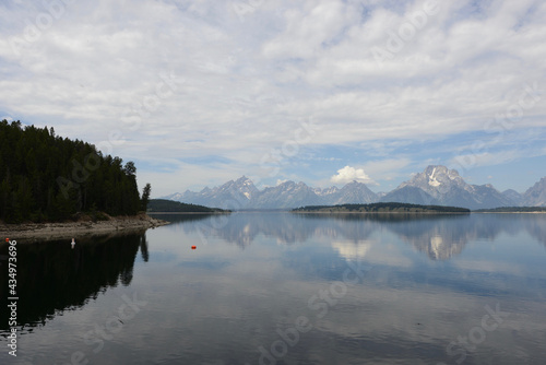 Scenic view of a lake with mountains in the background and lake reflections in Grand Teton National Park on a cloudy day