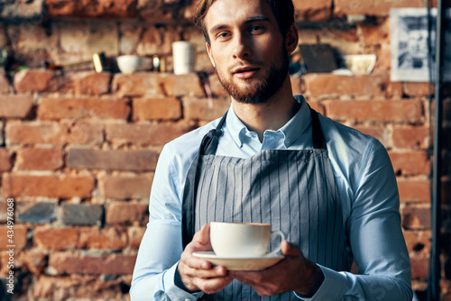 man in apron barista work professional a cup of coffee in hand