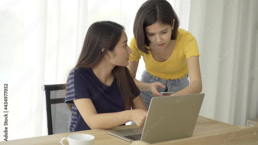 4K Young beautiful Asian couple love friend woman working look at smartphone and computer notebook laptop on table at home which smiling and felling happy, LGBT woman love work at home business 4K Young beautiful Asian couple love friend woman working look at smartphone and computer notebook laptop on table at home which smiling and felling happy, LGBT woman love work at home business