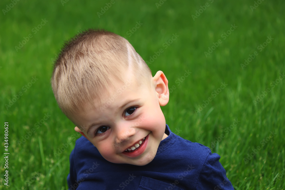 little boy sits on the grass. Selective focus little boy sits on the grass. Selective focus
