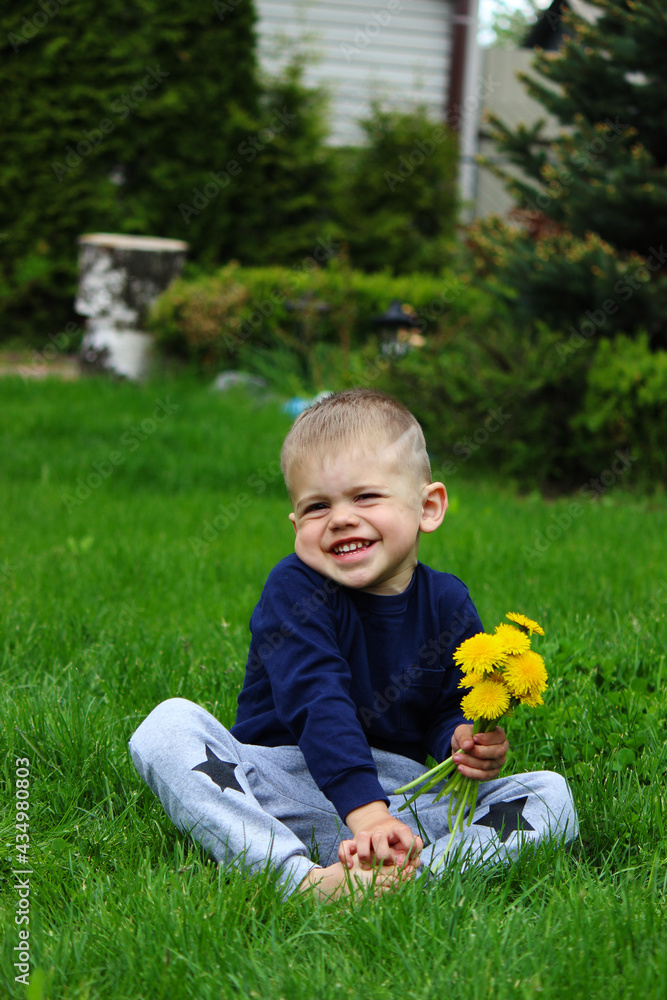 little boy sits on the grass. Selective focus little boy sits on the grass. Selective focus