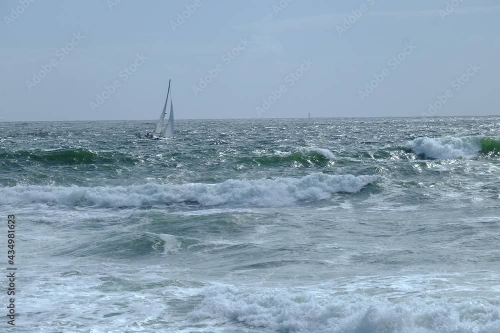 A sailing boat going against a strong wind. May 2021, France.