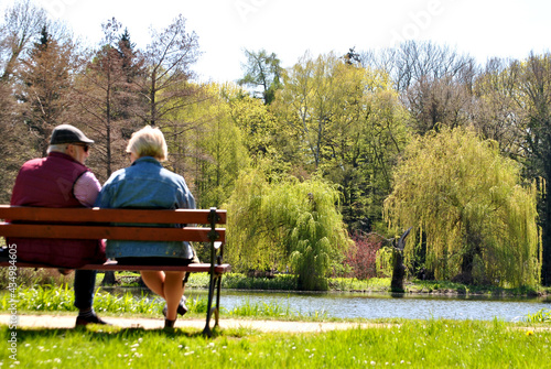 Dwoje starszych ludzi siedzącą na ławce w parku © Radosaw