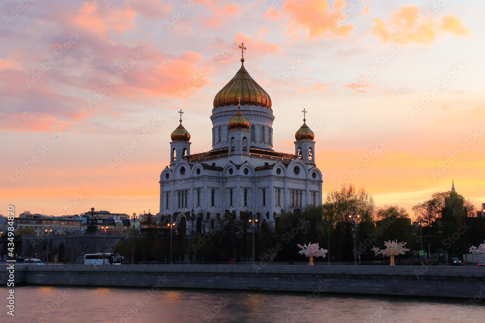 Orange sunset in Moscow: the view of the Cathedral of Christ the Savior and the pedestrian Patriarshy Bridge.