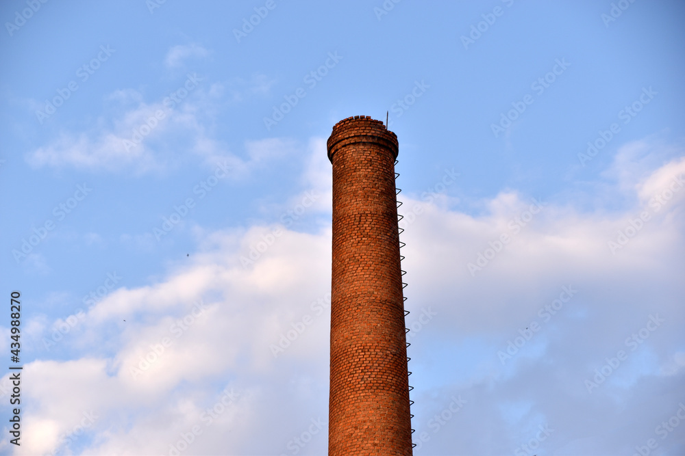 Red smokestack in the afternoon in the city against the sky