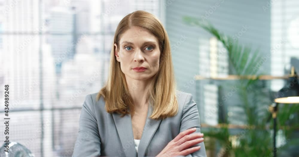 Close up of young beautiful serious female worker looking at camera in modern cabinet. Concentrated pretty woman in room at workplace, businesswoman, professional, office style concept Close up of young beautiful serious female worker looking at camera in modern cabinet. Concentrated pretty woman in room at workplace, businesswoman, professional, office style concept