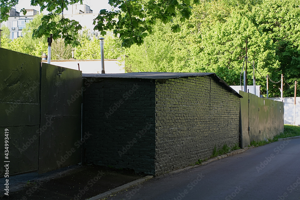 A brick building and fence painted gray A brick building and fence painted gray
