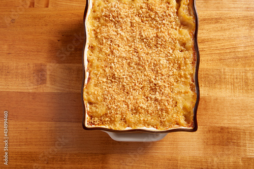 Top view of Mac n Cheese in a ceramin baking pan on a wooden surface photo