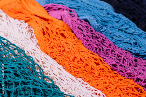 The pattern of multi-colored string bags was shot in macro style. Bright colors for your eco-friendly design.