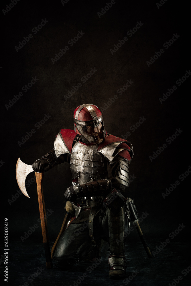 Portrait of a medieval fighter kneeling, holding an ax Portrait of a medieval fighter kneeling, holding an ax