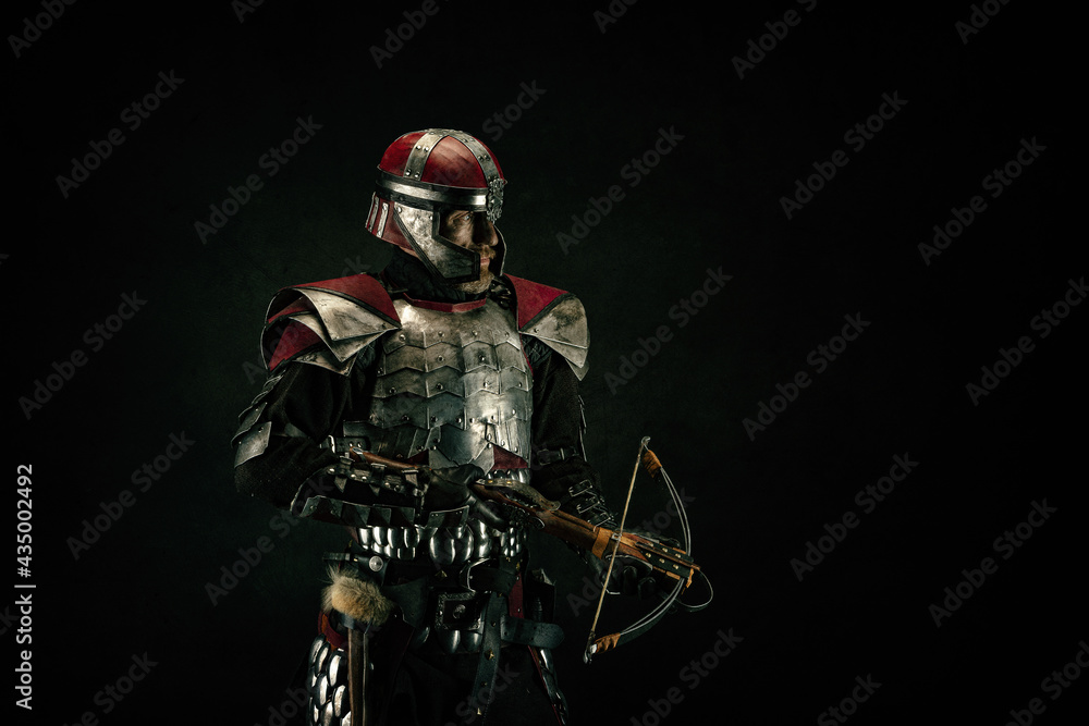 Portrait of a medieval fighter holding a crossbow in his hands