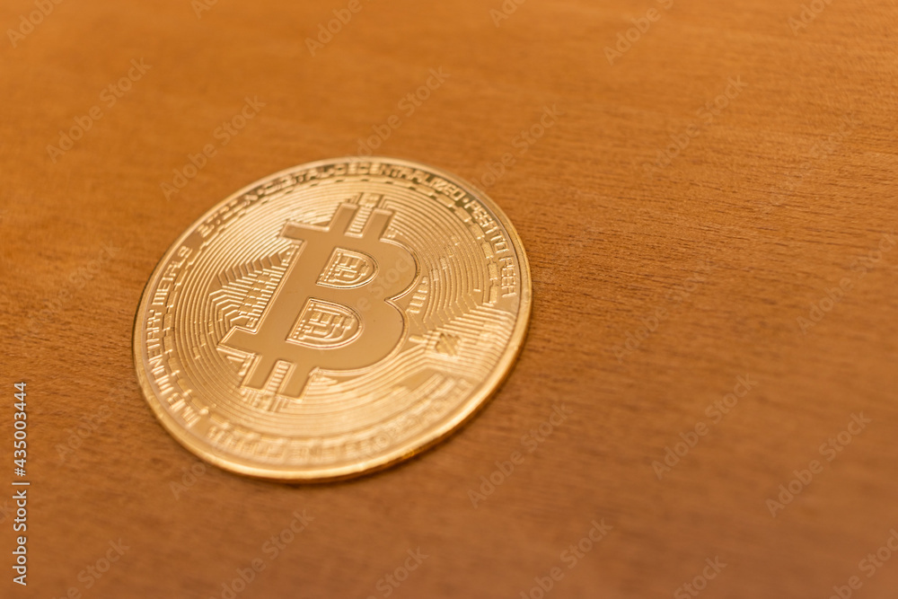 close up on bitcoin coin, wooden background, very short depth of field close up on bitcoin coin, wooden background, very short depth of field
