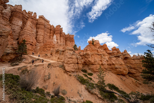 Unrecognizable hikers traverse the Queens Garden and Navajo loop trail inside Bryce Canyon National Park