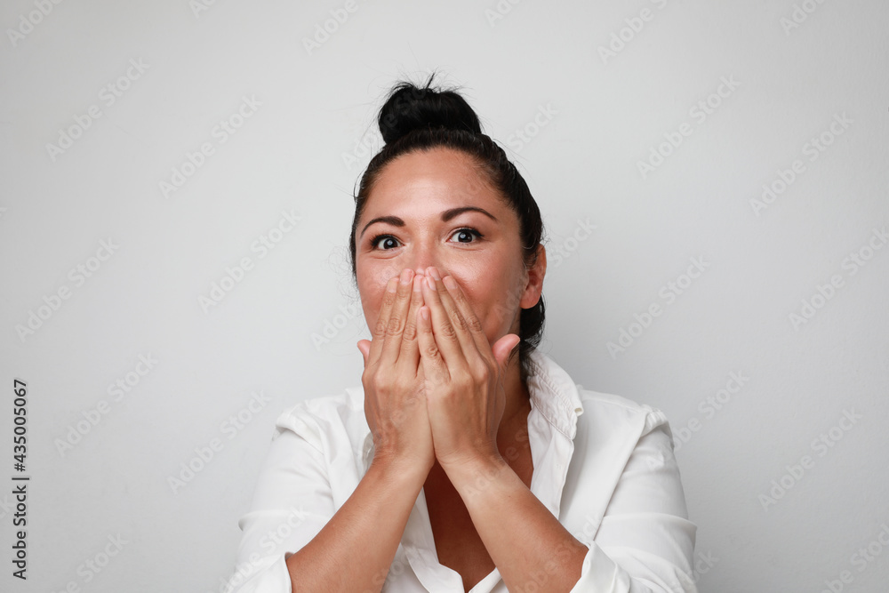Portrait of young surprised woman smiling and covering her face. Isolated. Portrait of young surprised woman smiling and covering her face. Isolated.