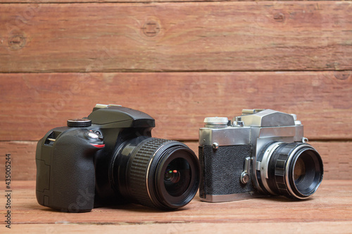 Foto Modern and old professional photo camera with telephoto lens on wooden planks