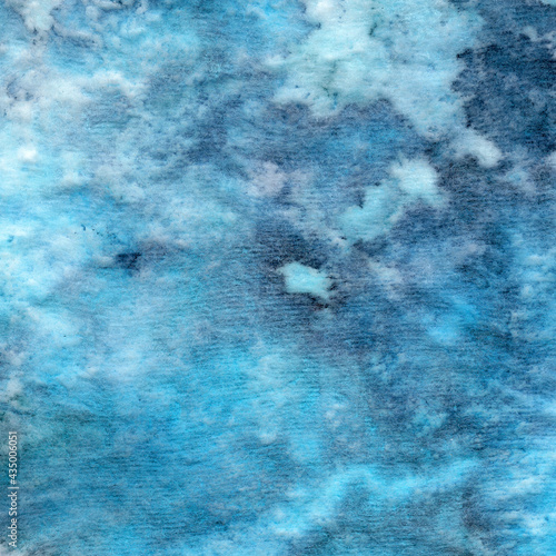 Abstract blue textile background — painting on fabric with colored spots, smudges and stains. Fluid texture resembles soft blanket, cotton or wool background in close up shot.