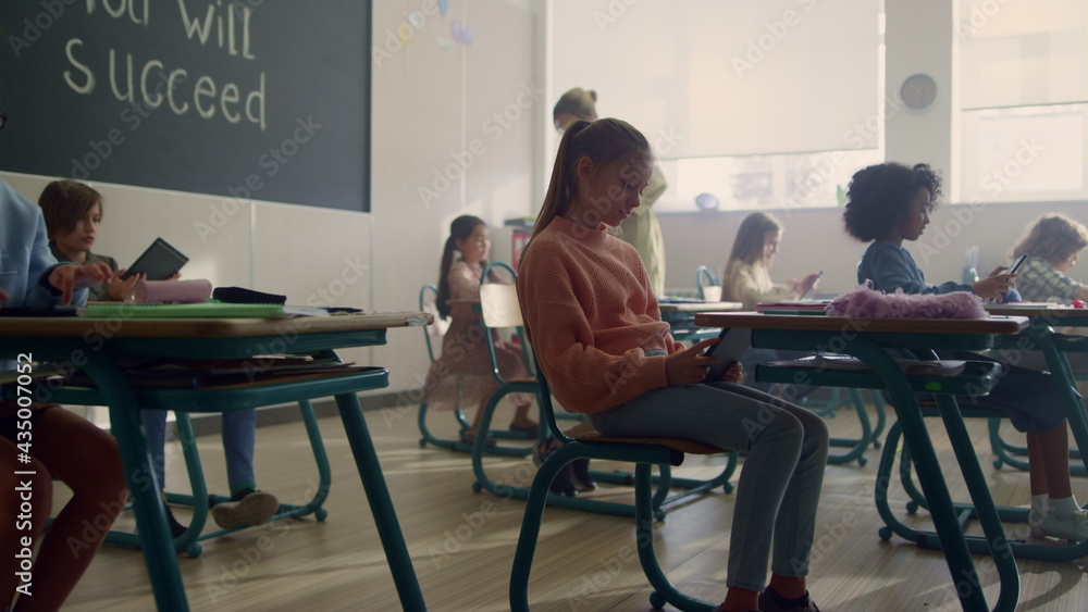 Fototapeta premium Children using digital tablets at lesson. Girl holding tablet computer
