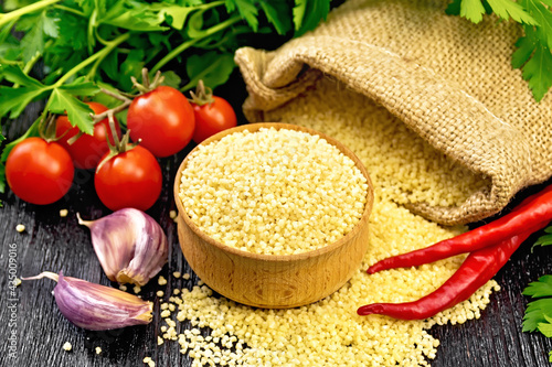 Slika na platnu Couscous raw in bowl on dark board