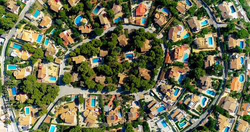 Aerial view with a drone above beautiful villas in a suburban community in Spain. Perfect family environment for everyday life. We can see rooftops and garden 4K 