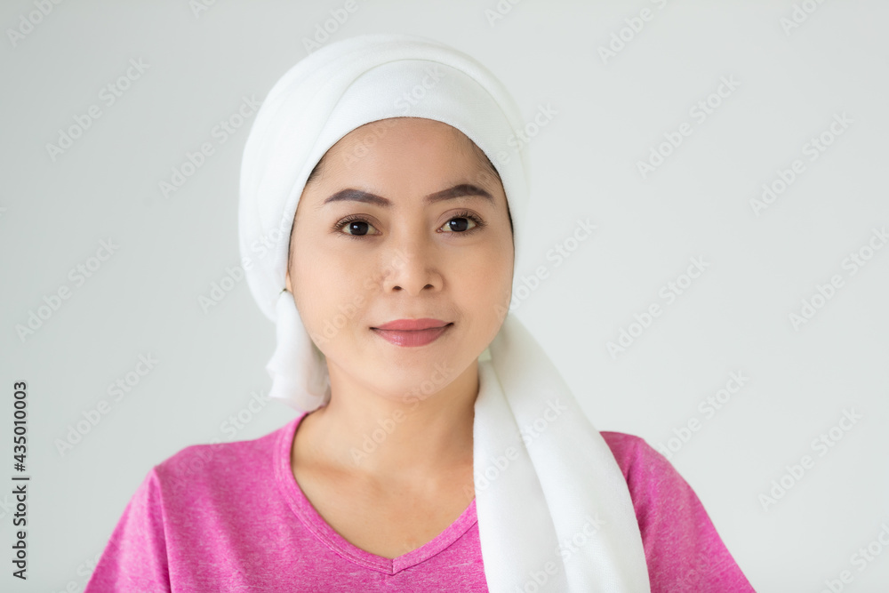 Portrait of a woman cancer patient with clothes covered around head affected from chemotherapy cure process posing with positive and self-confidence Portrait of a woman cancer patient with clothes covered around head affected from chemotherapy cure process posing with positive and self-confidence