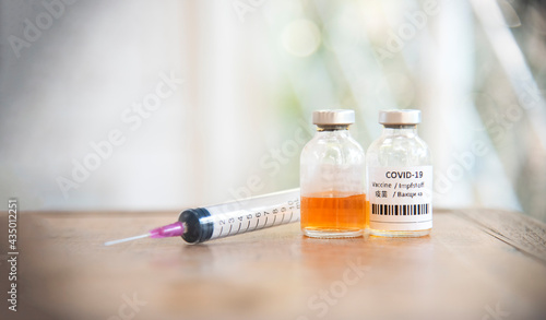 syringe with COVID-19 vaccine as positive concept immunization population against against coronavirus infection background.