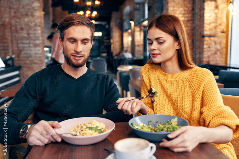 a man and a woman are sitting at a table in a restaurant meal delicious food serving dishes