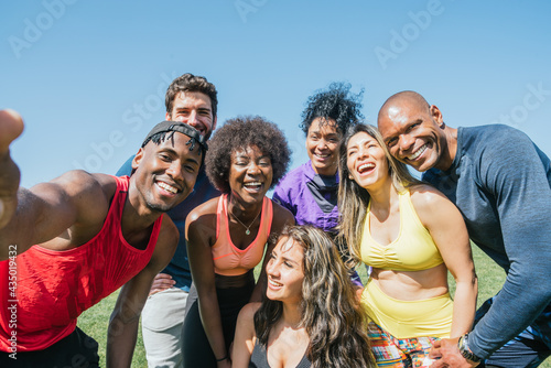 Group of runners taking a selfie in a park. Happy and smiling.