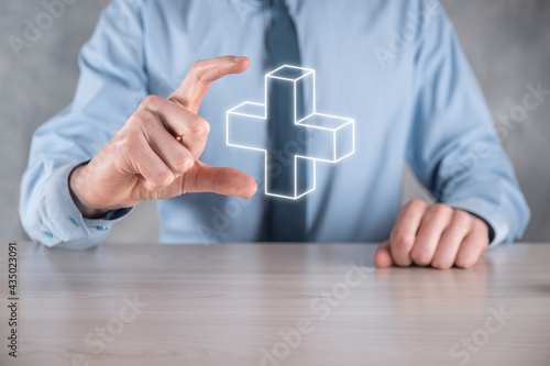 Businessman hold 3D plus icon, man hold in hand offer positive thing such as profit, benefits, development, CSR represented by plus sign.The hand shows the plus sign