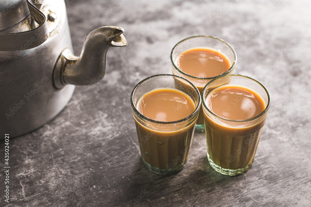 Indian chai in glass cups with metal kettle and other masalas to make the  tea. Stock Photo