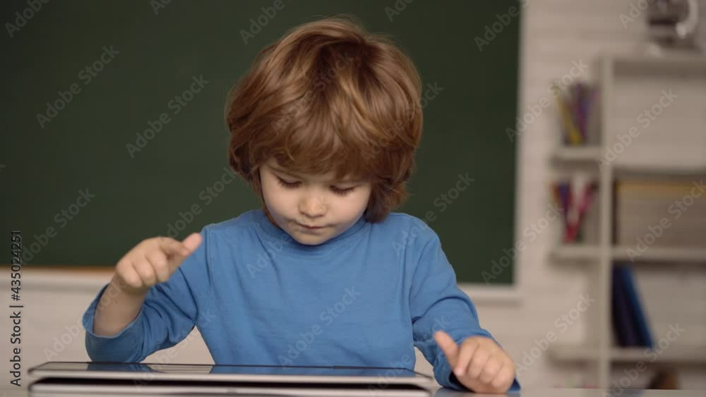Kid with tablet. Child using digital laptop. Home schooling. E-learning and online education concept. Kid with tablet. Child using digital laptop. Home schooling. E-learning and online education concept.