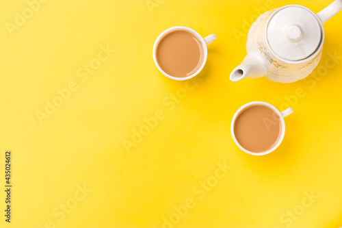 Photography Milk tea on white cup with white kettle on yellow background stock image