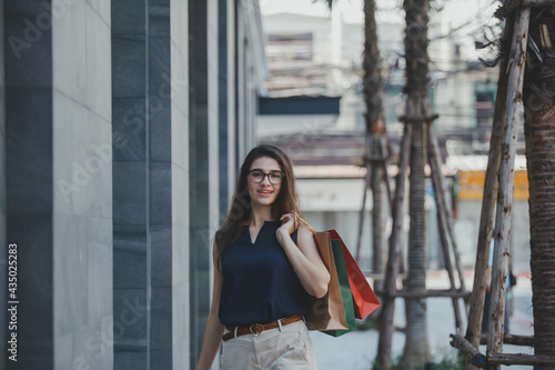 Young woman with shopping bags. Happy woman with shopping bags enjoying in shopping. lifestyle concept. Fashion woman with shopping bags walking on street. © nikomsolftwaer