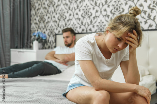 Sad couple after conflict in bedroom at home