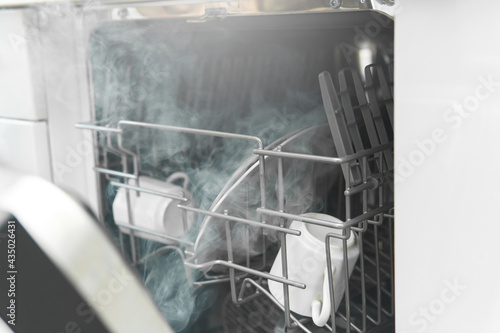 Dishwasher with a plates, cups and other dishware photo