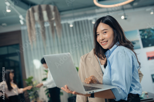 Business woman working online on a laptop. Portrait of a happy asian businesswoman working on laptop computer Free Download Business woman working online on a laptop. Portrait of a happy asian businesswoman working on laptop computer - GFXLoad
