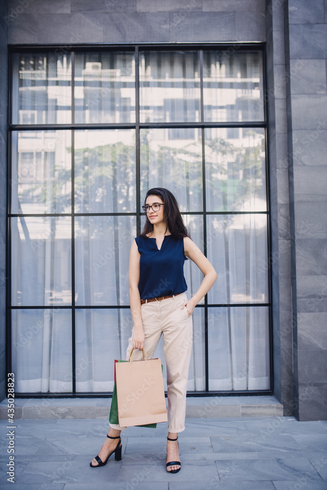 Young woman with shopping bags. Happy woman with shopping bags enjoying in shopping. lifestyle concept. Fashion woman with shopping bags walking on street. Young woman with shopping bags. Happy woman with shopping bags enjoying in shopping. lifestyle concept. Fashion woman with shopping bags walking on street.