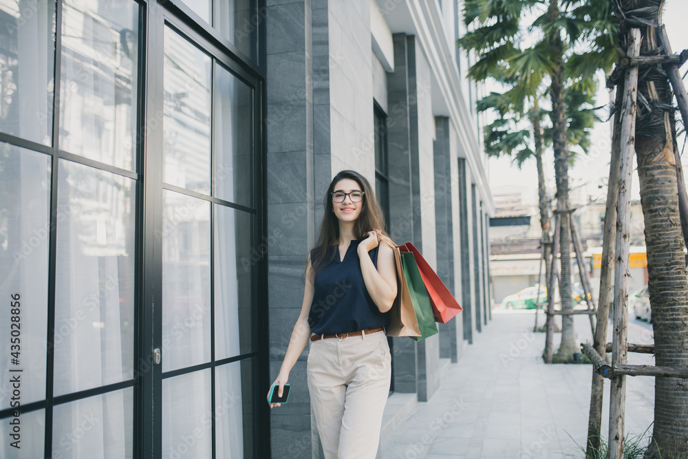 Young woman with shopping bags. Happy woman with shopping bags enjoying in shopping. lifestyle concept. Fashion woman with shopping bags walking on street.