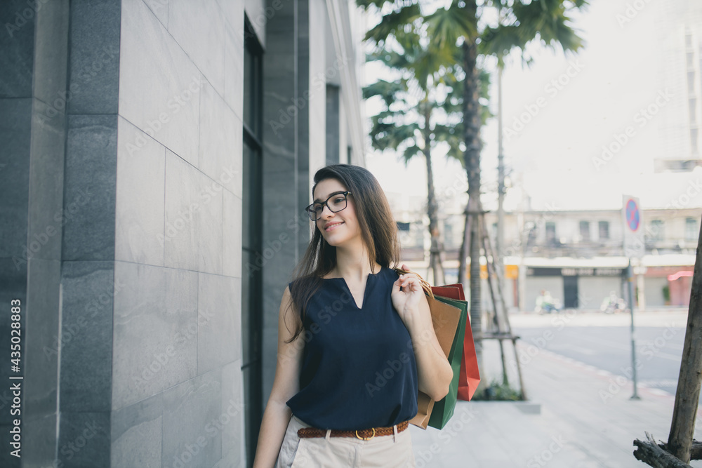 Young woman with shopping bags. Happy woman with shopping bags enjoying in shopping. lifestyle concept. Fashion woman with shopping bags walking on street. Young woman with shopping bags. Happy woman with shopping bags enjoying in shopping. lifestyle concept. Fashion woman with shopping bags walking on street.