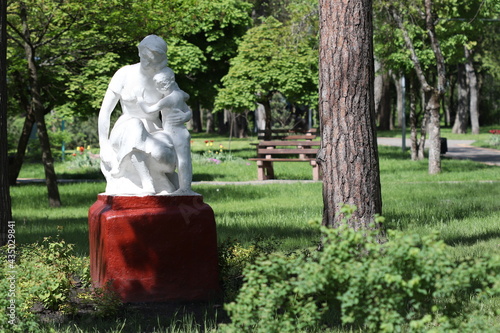An old sculpture of a mother with a child in a park, Soviet times. 